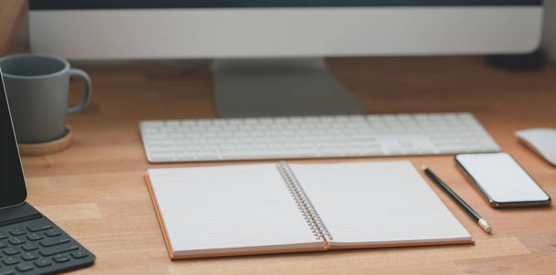 Cropped shot of modern workspace with office supplies and desktop computer on wooden table  - 写真・画像