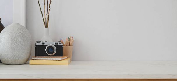 白い机と白い壁の背景にコピースペース、カメラとオフィス用品と最小限のワークスペース  - 写真・画像