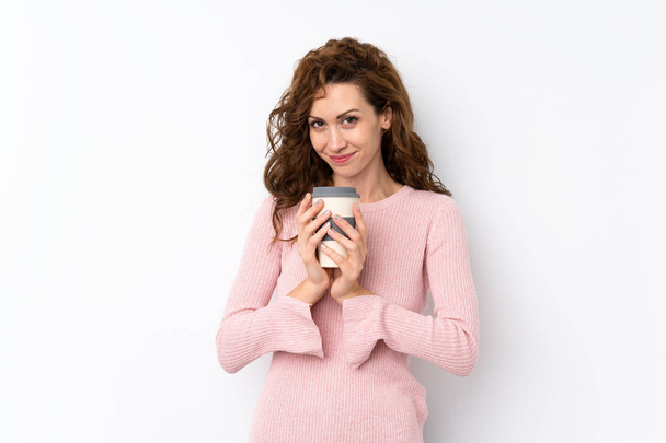 Genç, güzel bir kadın, izole edilmiş bir arka planda elinde kahve tutuyor. - Fotoğraf, Görsel