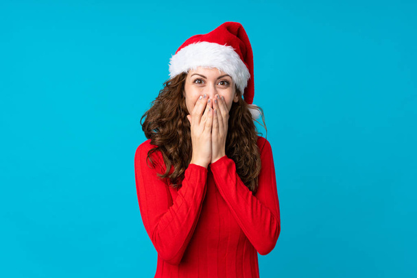 Mädchen mit Weihnachtsmütze über isoliertem gelben Hintergrund mit überraschendem Gesichtsausdruck - Foto, Bild
