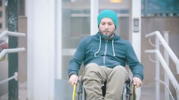 Behinderter im Rollstuhl fährt vom speziellen Aufzug für Behinderte weg - Filmmaterial, Video