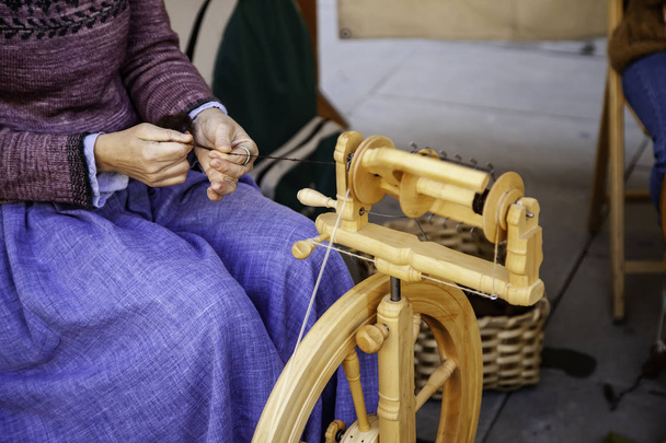 Spinning with a wooden spinning wheel - 写真・画像
