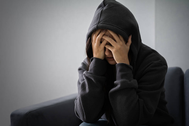 Young Depressed Woman In Hoodie Sitting On Sofa At Home - Foto, Imagen