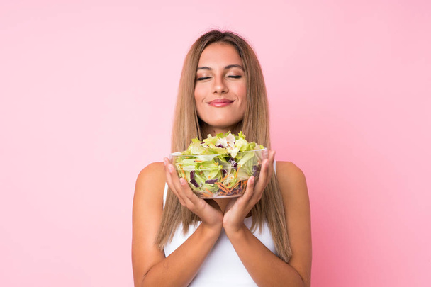 Giovane donna bionda con insalata su sfondo isolato
 - Foto, immagini
