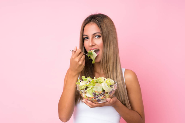 Young blonde woman with salad over isolated background - Foto, immagini