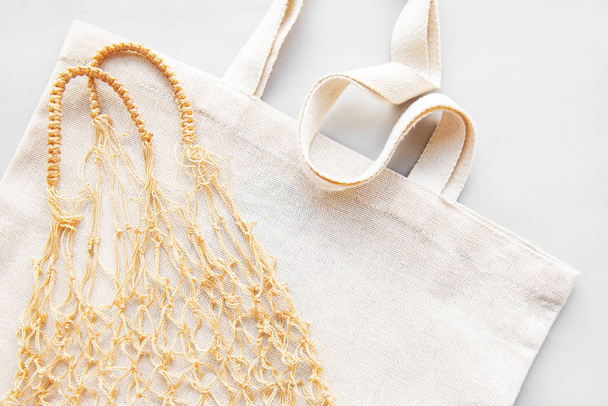 Reusable shopping bags on white background. Ecological concept. Top view of mesh bag and cotton bag. Caring for the environment and the rejection of plastic. - 写真・画像