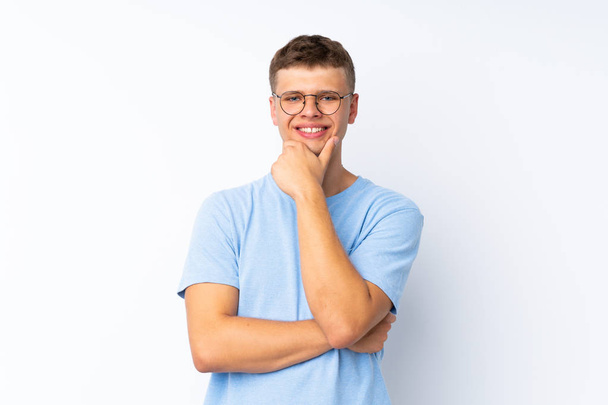 Joven hombre guapo sobre fondo blanco aislado con gafas y sonriendo
 - Foto, imagen