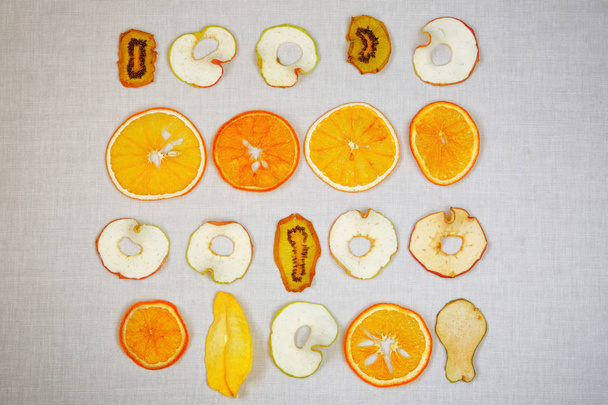 Armut, elma, kivi ve portakaldan yapılmış meyveli cipsler. Kuru meyve, set, dilimler. Meyve deseni. Üst manzara, düz uzanma. - Fotoğraf, Görsel