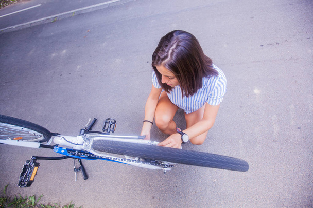 Молода жінка перевіряє свій велосипед
 - Фото, зображення