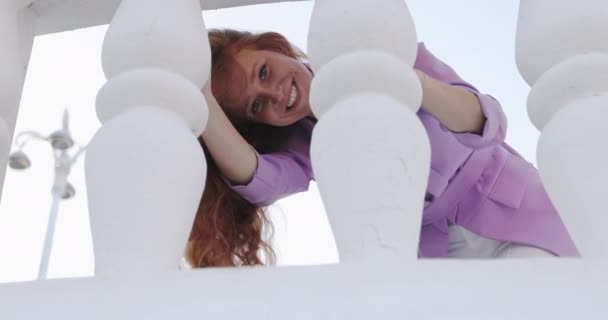 A girl with curly long red hair having a fun outdoors. - Video, Çekim