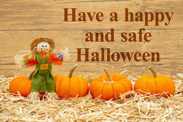 Feliz mensaje de Halloween con espantapájaros y calabazas naranjas en st
 - Foto, imagen