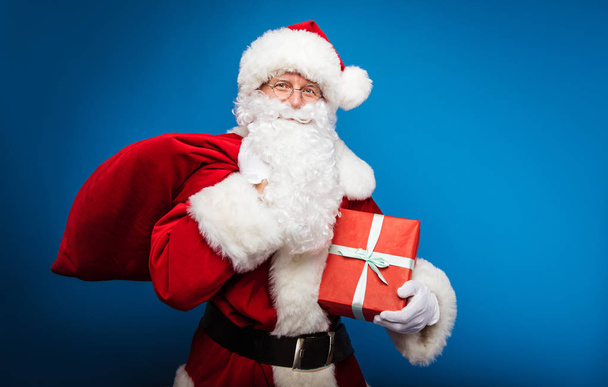  Christmas and New year concept.  Portrait of man in Santa Clause costume  with present - Photo, image