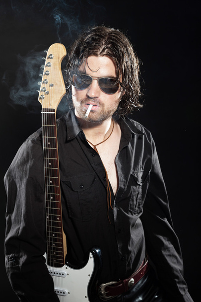 ροκ κιθαρίστας με μακριά καστανά μαλλιά και γένια και γυαλιά ηλίου dre - Φωτογραφία, εικόνα