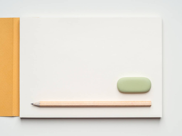 Flat blank template with sketchbook, pencil and eraser on white background - Fotografie, Obrázek