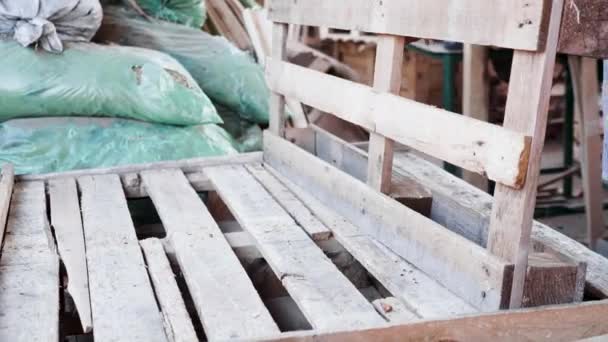 Άνδρας εργάτης σε εργοστάσιο ξυλείας με καρφωτικό που φτιάχνει ξύλινη παλέτα. - Πλάνα, βίντεο