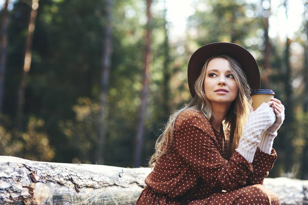 Beautiful woman drinking hot coffee in autumn forest - Fotografie, Obrázek