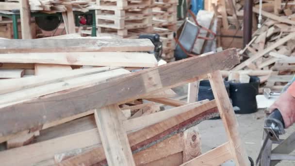Mann zersägt Holzpalette in Wohnhaus mit der Motorsäge - Filmmaterial, Video