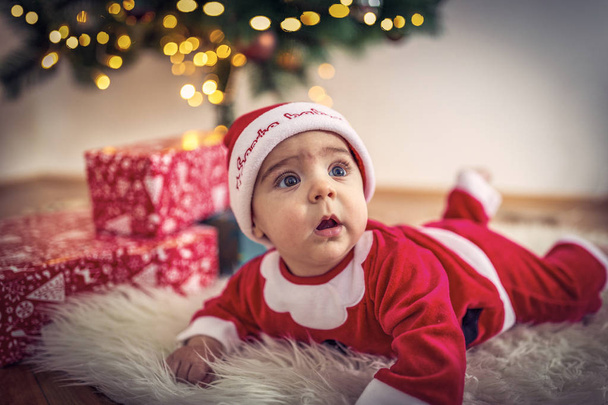Bambino in costume da Babbo Natale nella stanza di Natale a Natale d
 - Foto, immagini