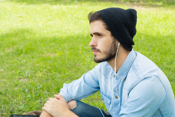 Young man listening to music with earphones - Foto, imagen
