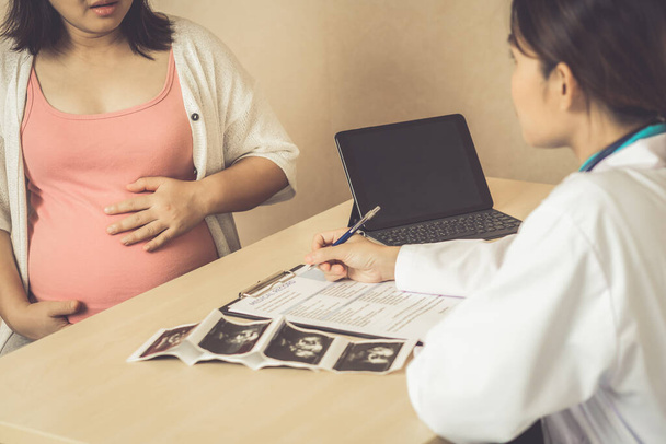 Mulher grávida feliz visitando médico ginecologista no hospital ou clínica médica para consultor de gravidez
. - Foto, Imagem