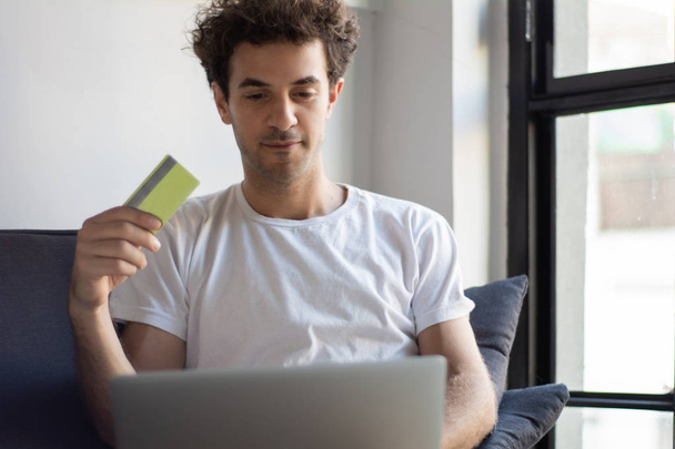Man with laptop and credit card at home.  - Foto, Imagem