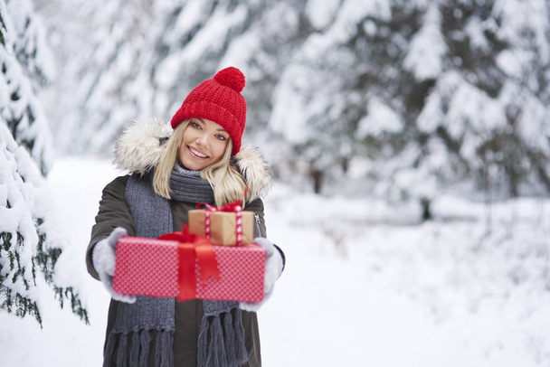 Portrait de femme souriante donnant deux cadeaux de Noël
 - Photo, image