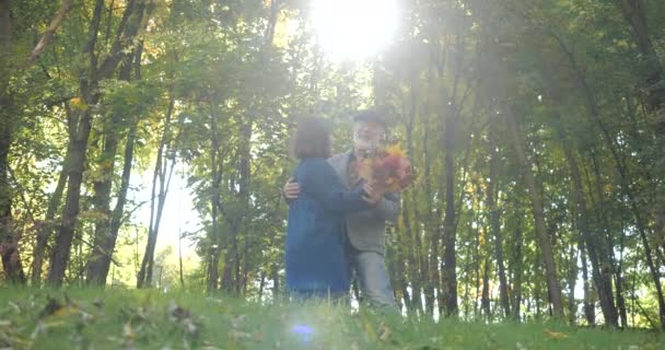 Ein fröhliches älteres Paar tanzt im Herbst zwischen den Bäumen und genießt seinen Zeitvertreib - Zeitlupe. gutes Lachen. - Filmmaterial, Video
