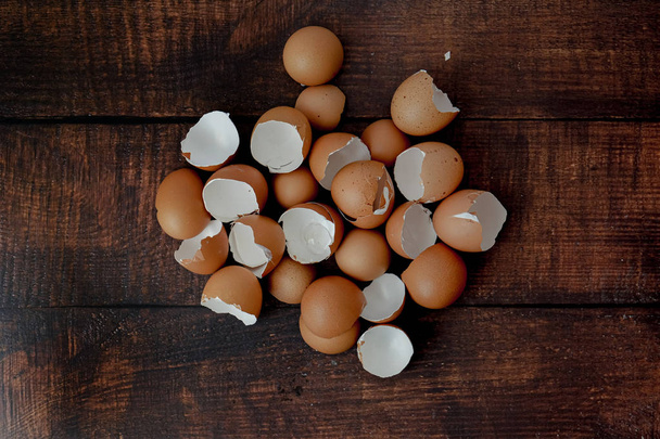 huevos marrones rotos esparcidos sobre un fondo de madera
 - Foto, Imagen