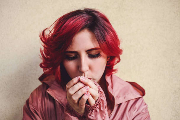 A girl with red hair warms her hands from the cold  - Foto, immagini