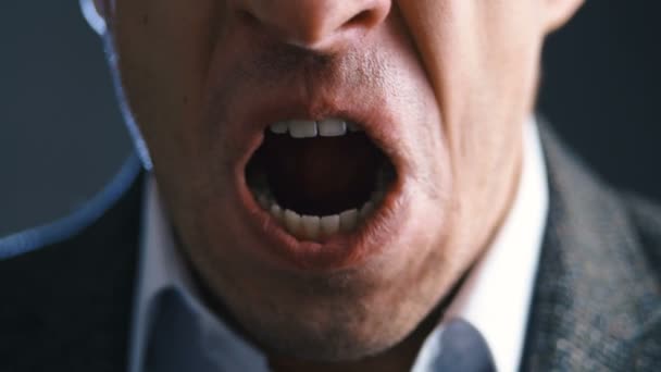 Close-up mouth of angry annoyed boss man screaming at camera. Businessman aggressively shouts experiencing stress at work. - Footage, Video