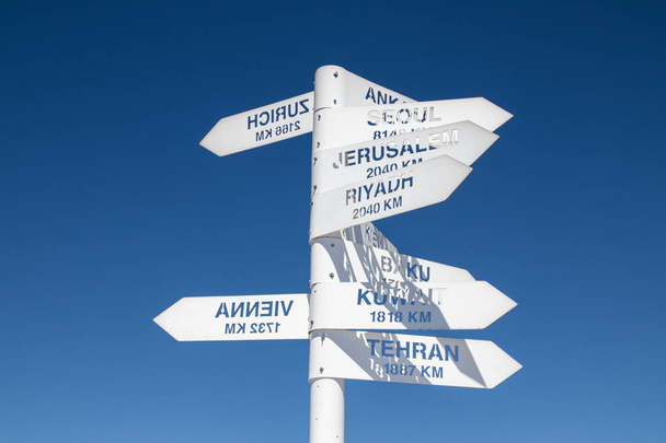 Знак, що вказує напрямок і відстань до великих міст світу проти блакитного неба. На вершині гори Тахталі знаходиться оглядовий майданчик. Кемер, Туреччина - Фото, зображення