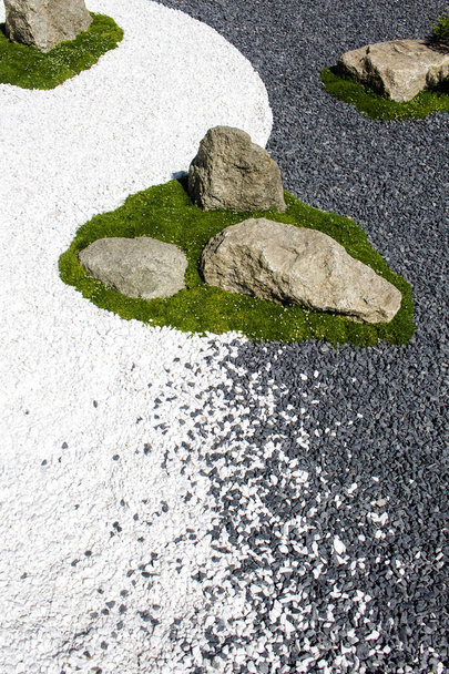 De eilandjes van rotsblokken en gras om hen heen op een zwart en wit - Foto, afbeelding