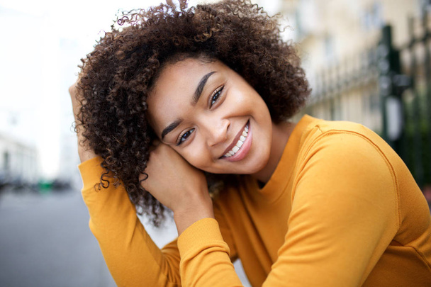 Close up portret pięknej, młodej Afroamerykanki uśmiechającej się z kręconymi włosami - Zdjęcie, obraz