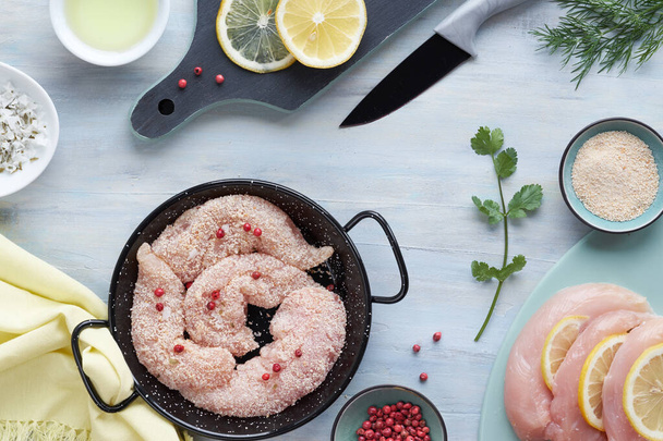Raw chicken fillet. Meat with breadcrumbs, herbs , lemon and coo - Fotoğraf, Görsel