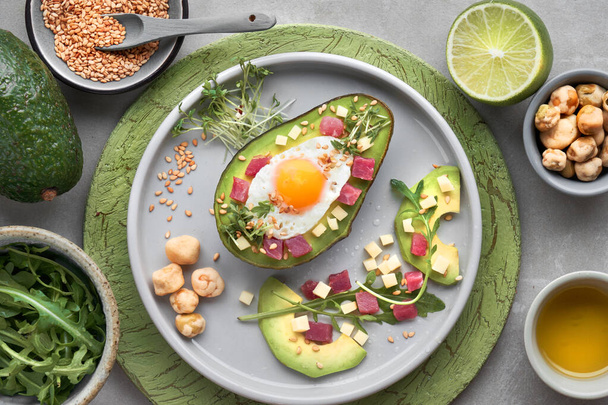 Keto diet dish: baked Avocado boat with ham cubes, quail egg and - Photo, Image