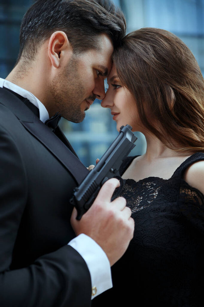 Portrait of an elegant man with guns in hands of a beautiful girl. - Foto, Imagen