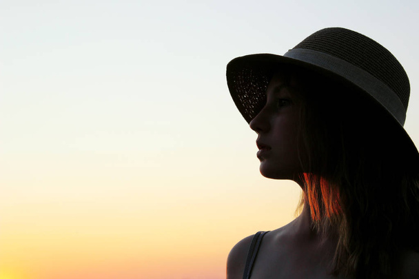 Rozmazaný obraz mladé dívky v klobouku a dívající se do strany, krásné nebe pekárny. Lidi, pojetí cestování. - Fotografie, Obrázek