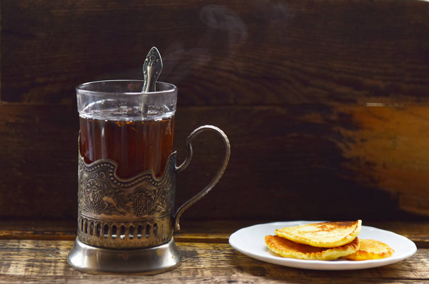 блины с черным чаем из сгущенного молока в держателе чашки
 - Фото, изображение