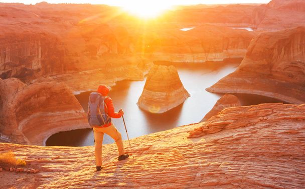 Fondo natural inusual. Reflection Canyon on Lake Powell, Utah, EE.UU. Inspirador senderismo escena-hombre descansando en el hermoso punto de puesta del sol
. - Foto, imagen