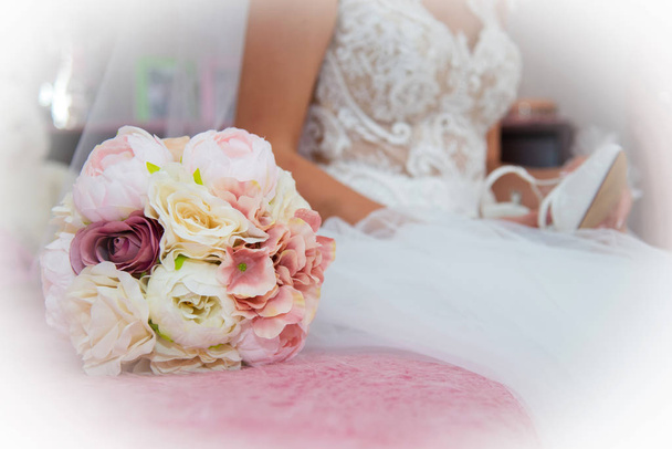 Όμορφη νύφη σε νυφικό και μπουκέτο με ροζ και λευκά άνθη. Επιλεκτική εστίαση. Χώρος κειμένου. - Φωτογραφία, εικόνα