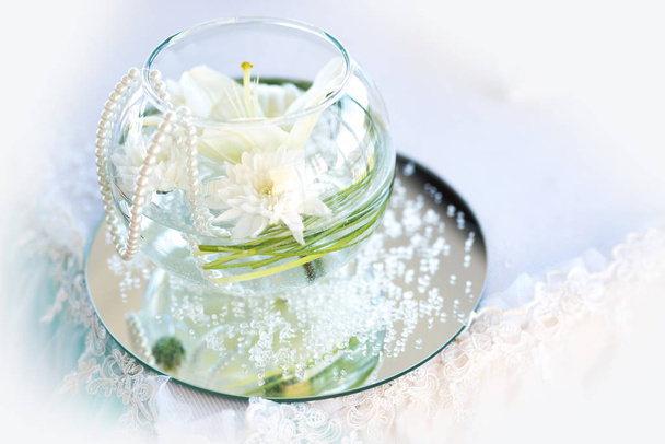 Wedding table decoration in a restaurant - glass sphere with white flowers, pearls and lace - selective focus - Φωτογραφία, εικόνα