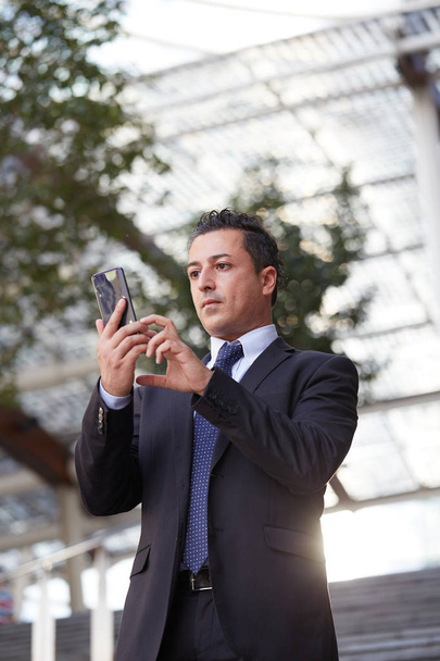 businessman talking to mobile in urban environment - Fotó, kép