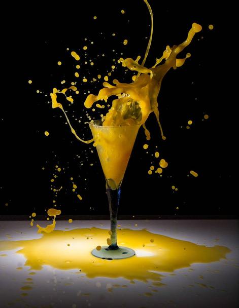 Пийте коктейль з персикового соку бризки скла з замерзлими краплями на чорному тлі
. - Фото, зображення