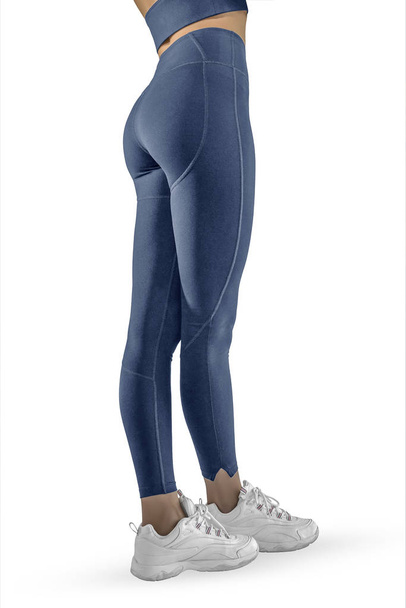Krásné štíhlé ženské nohy v modrých sportovních kamaších a běžecké boty izolované na bílém pozadí. Koncept stylového oblečení, sportu, krásy, módy a štíhlých nohou - Fotografie, Obrázek