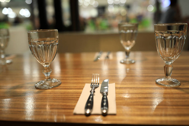 Wooden dining table with cutlery - 写真・画像