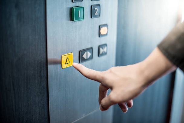 Мужская рука нажимает на аварийную кнопку в лифте
 - Фото, изображение