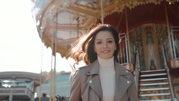 Young adult lady walking near carousel and smiling wide - Video