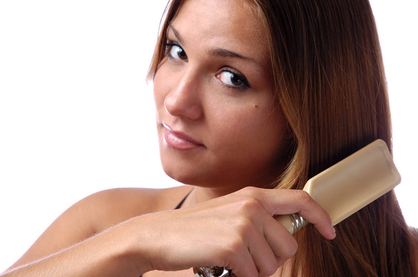 Nahaufnahme einer jungen Frau beim Kämmen der Haare - Foto, Bild