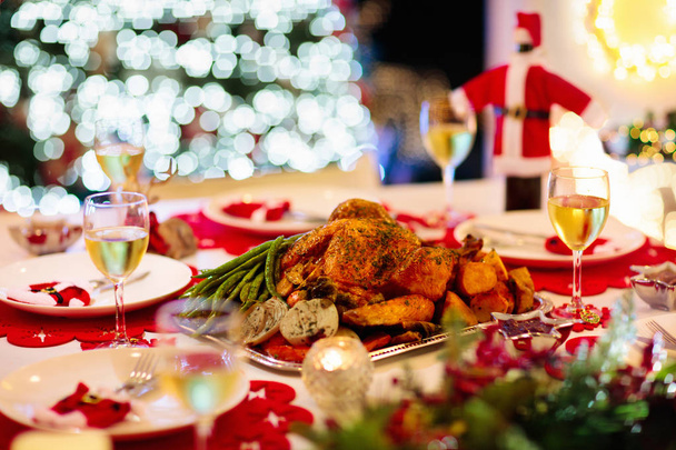 Χριστουγεννιάτικο δείπνο στο τζάκι και το χριστουγεννιάτικο δέντρο. - Φωτογραφία, εικόνα