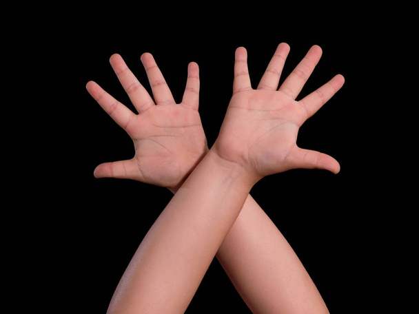 manos arriba de niño aislado sobre fondo negro
 - Foto, Imagen
